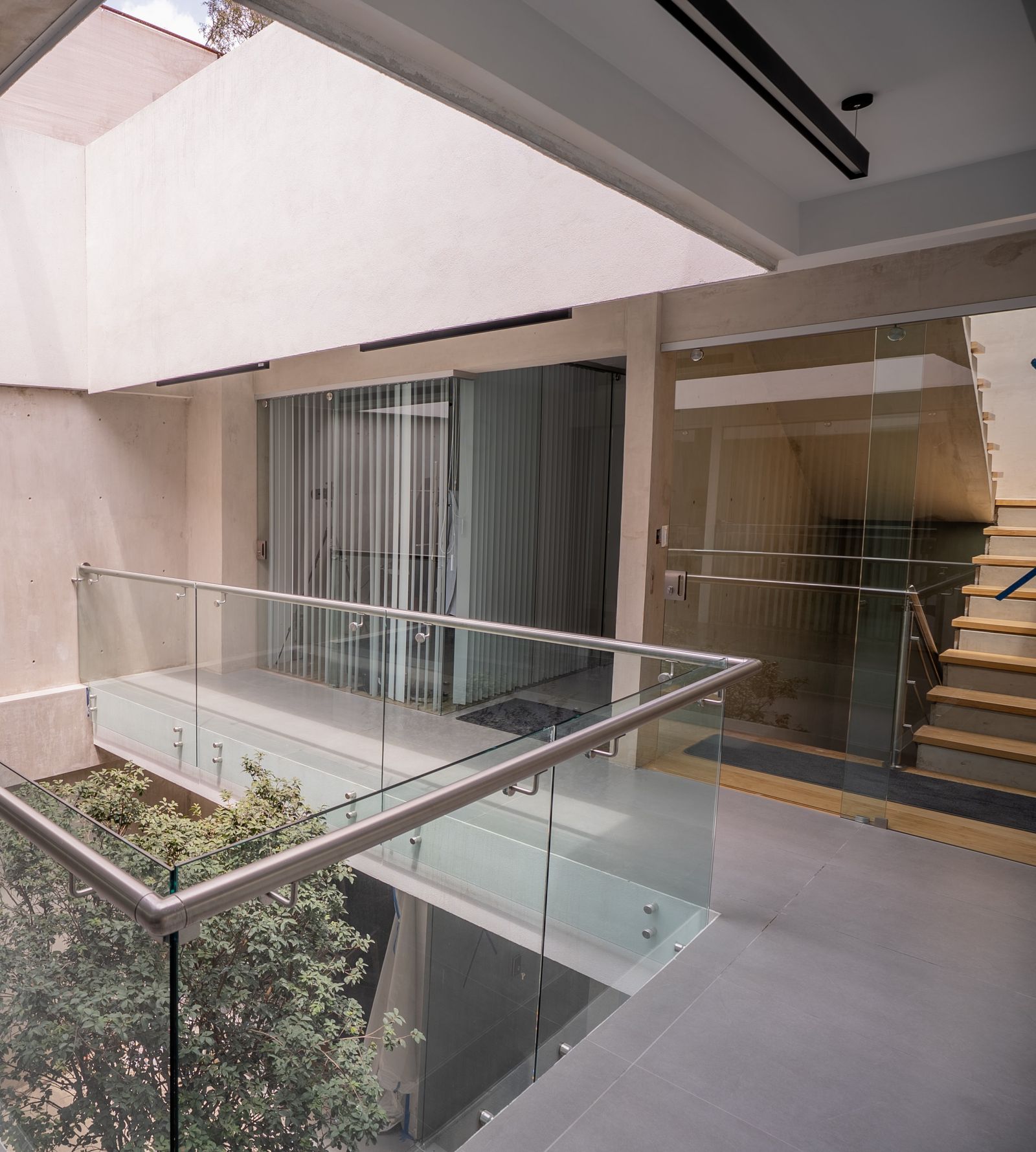 Patio de entrada con escaleras hacia la recepción en planta alta