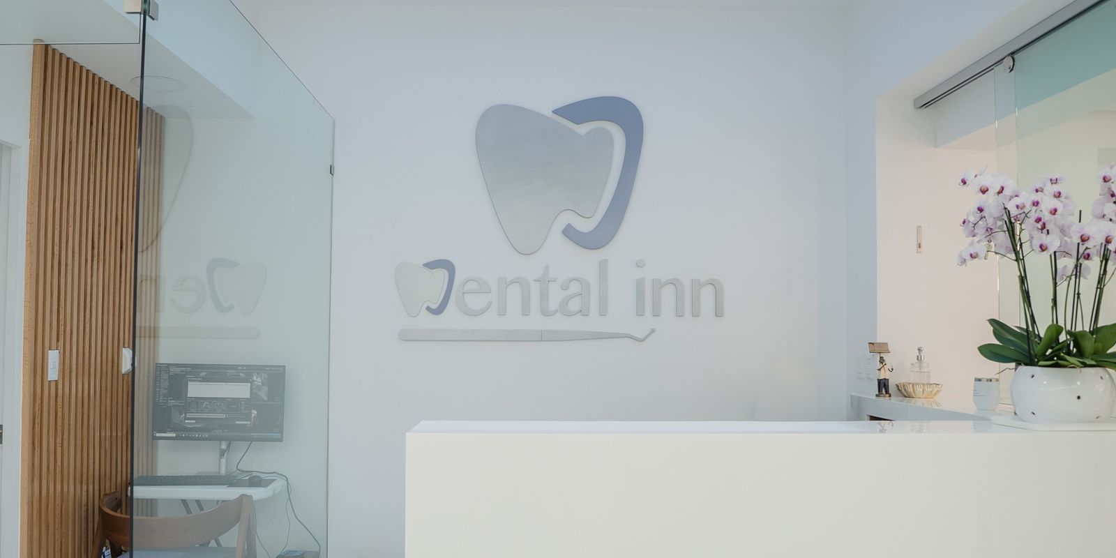 Recepción de Dental Inn con el logo en la pared