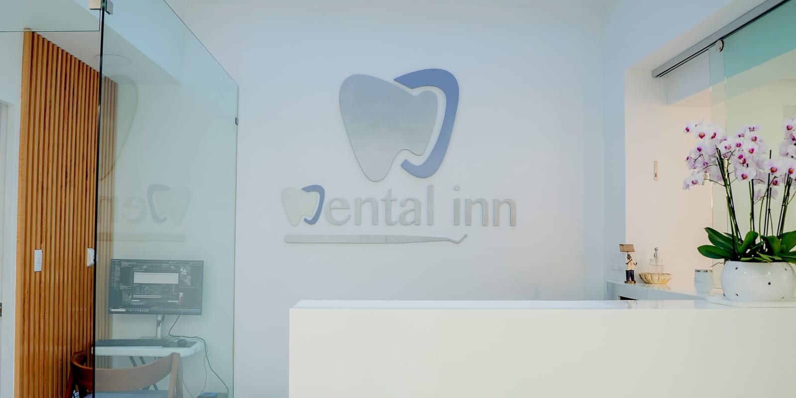 Recepción de Dental Inn con el logo en la pared